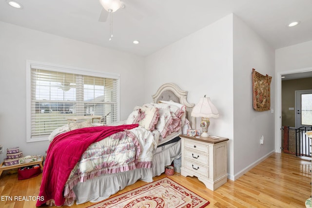 bedroom featuring multiple windows, ceiling fan, and light hardwood / wood-style flooring