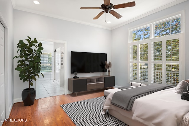 bedroom with baseboards, ensuite bathroom, crown molding, light wood-type flooring, and recessed lighting