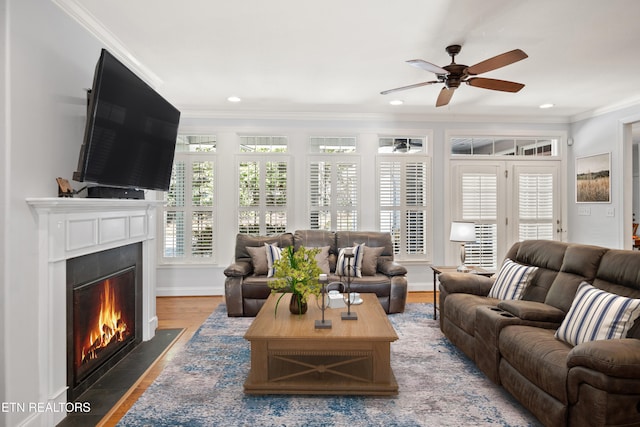 living room featuring baseboards, a fireplace with flush hearth, ornamental molding, wood finished floors, and recessed lighting