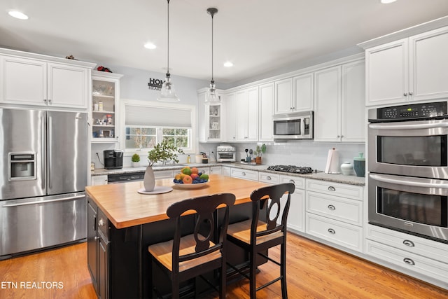 kitchen with white cabinetry, glass insert cabinets, and stainless steel appliances