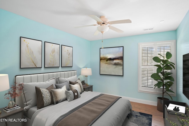 bedroom with visible vents, ceiling fan, baseboards, and wood finished floors