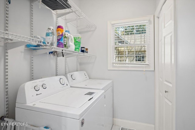 laundry room with laundry area, separate washer and dryer, and baseboards