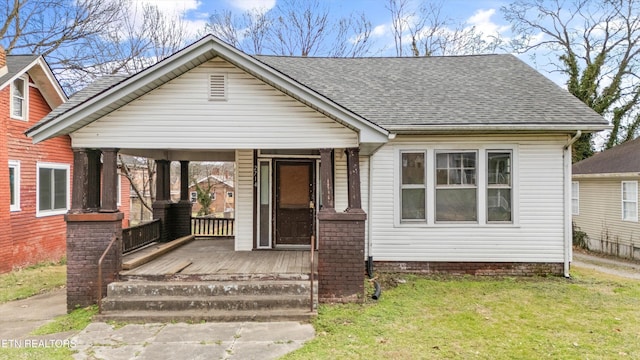 bungalow featuring covered porch and a front yard