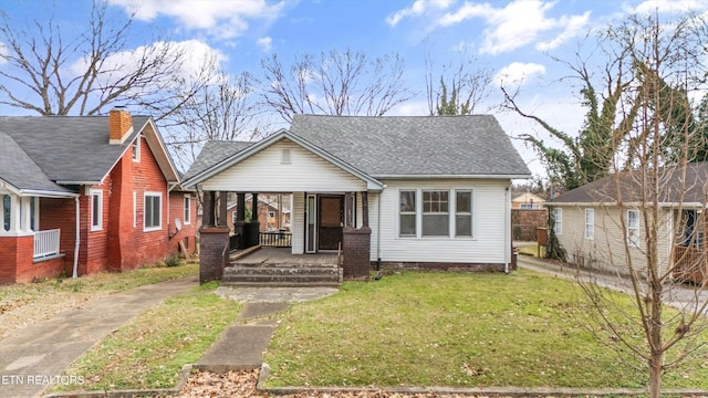 bungalow-style home with covered porch and a front lawn