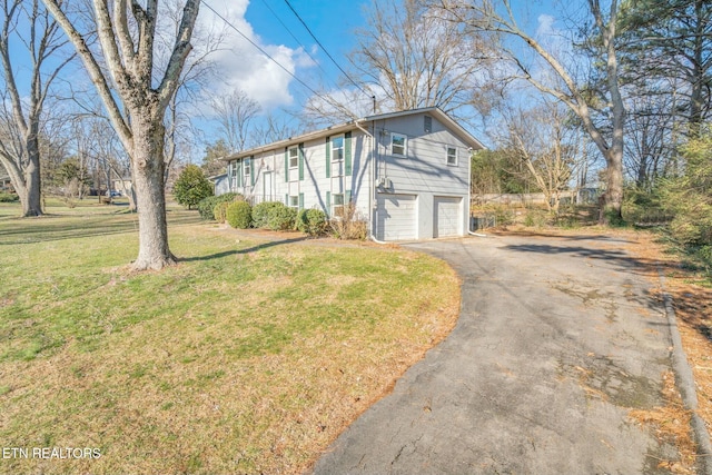 view of property exterior featuring a garage and a lawn