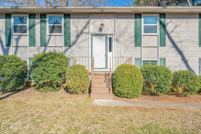 property entrance with a lawn