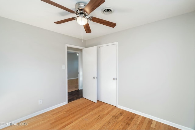 unfurnished bedroom featuring ceiling fan, light hardwood / wood-style floors, and a closet