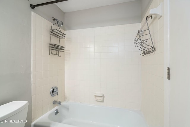 bathroom featuring tiled shower / bath combo and toilet