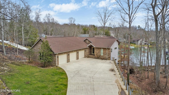 ranch-style house with a water view, a front yard, and a garage