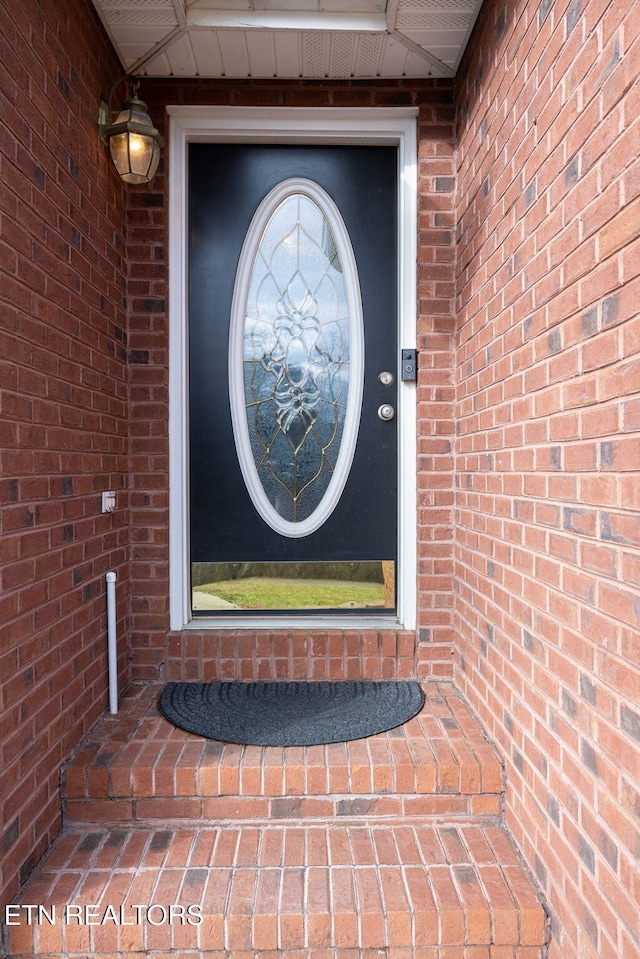 view of exterior entry with brick siding