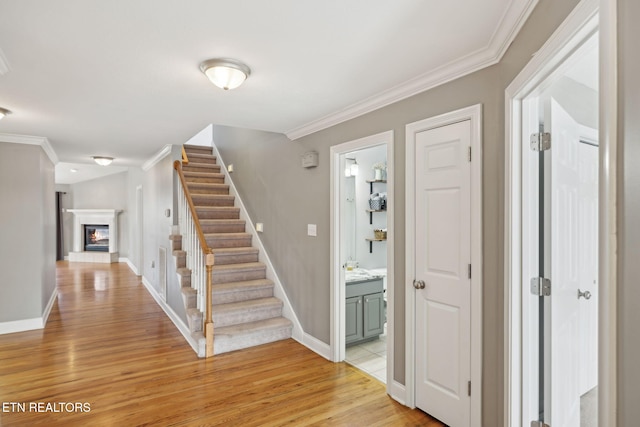 stairway featuring hardwood / wood-style flooring and crown molding