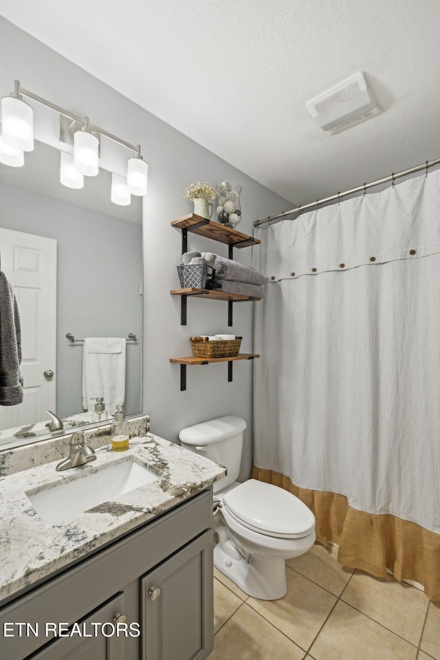 bathroom with curtained shower, visible vents, toilet, vanity, and tile patterned floors