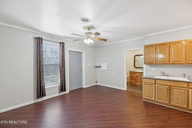 kitchen featuring ornamental molding, dark wood finished floors, a sink, and baseboards