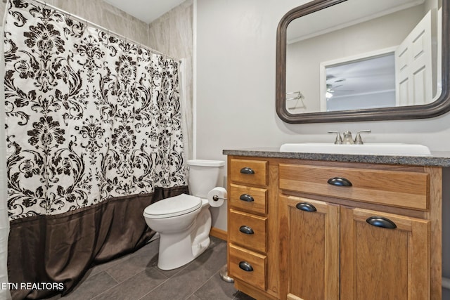 bathroom with toilet, vanity, and tile patterned floors