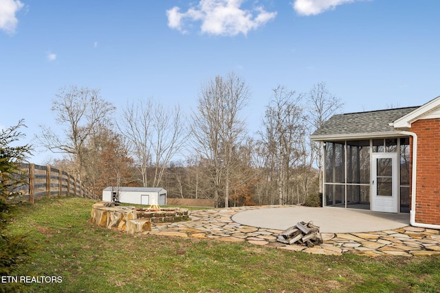 view of yard with a storage shed, a sunroom, a patio area, a fenced backyard, and an outdoor structure