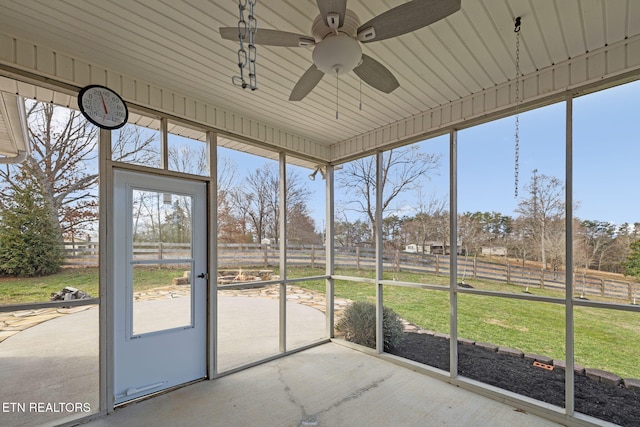 unfurnished sunroom featuring ceiling fan