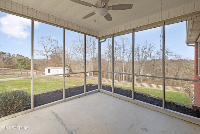 unfurnished sunroom with ceiling fan