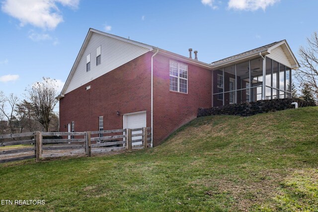 view of property exterior with brick siding, a lawn, fence, and a sunroom