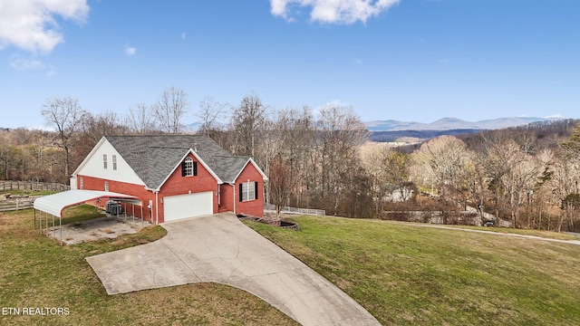 view of front of property with a garage, brick siding, a front yard, and a mountain view