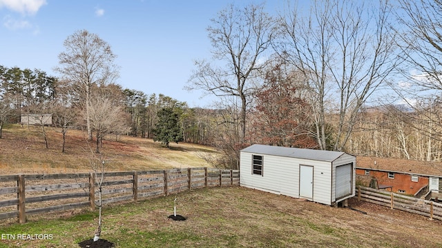 view of yard featuring an outbuilding, a rural view, fence, and a storage shed