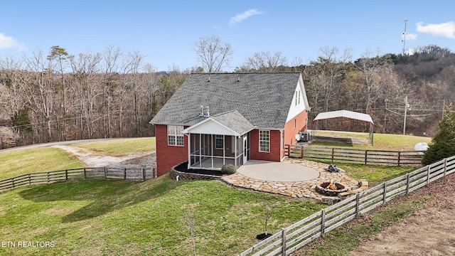 view of front of house with a patio, a front yard, fence, and a sunroom