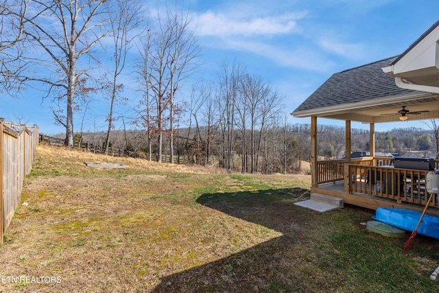 view of yard featuring a deck and ceiling fan