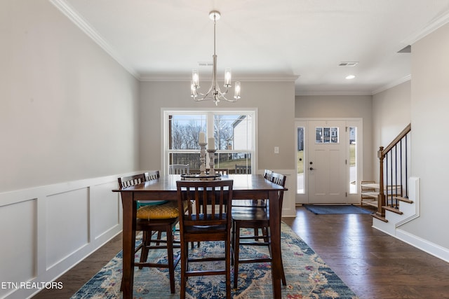 dining space featuring a chandelier, dark hardwood / wood-style flooring, and crown molding