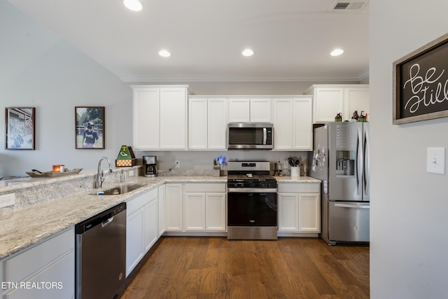 kitchen with sink, stainless steel appliances, white cabinets, light stone counters, and dark hardwood / wood-style flooring