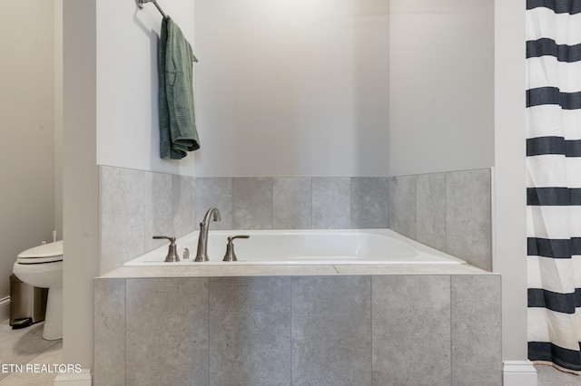 bathroom featuring toilet and tiled tub