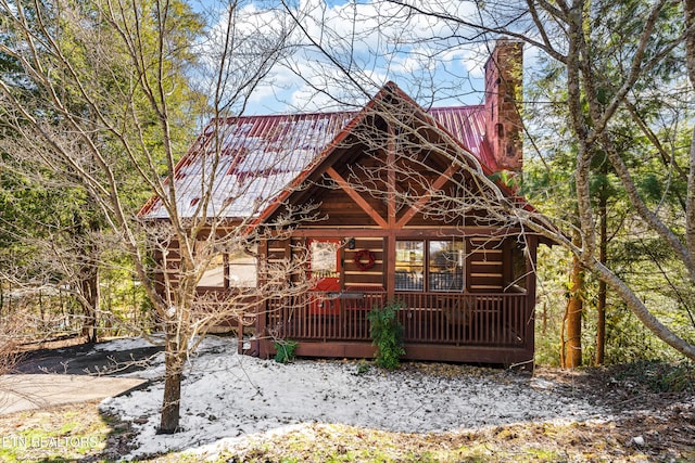 log home featuring metal roof and a chimney