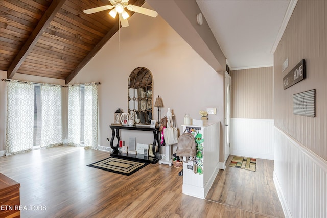 interior space with a wainscoted wall, wood ceiling, wood finished floors, high vaulted ceiling, and beamed ceiling