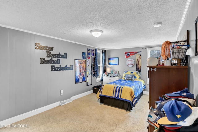 bedroom with carpet floors, a textured ceiling, visible vents, and crown molding