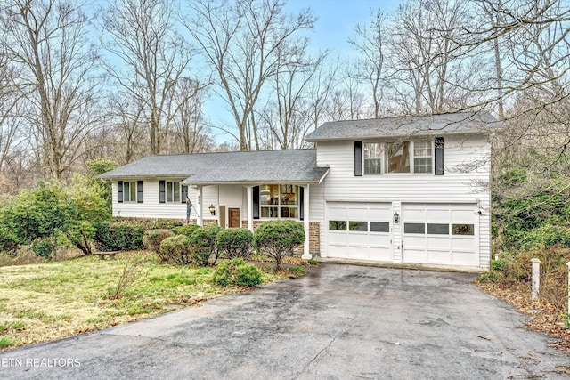 split level home with a garage and aphalt driveway