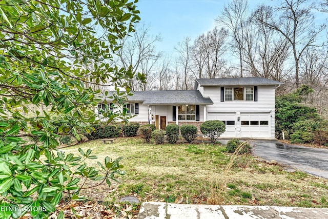 split level home featuring aphalt driveway and an attached garage