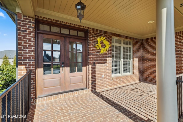 entrance to property featuring a mountain view, french doors, and covered porch