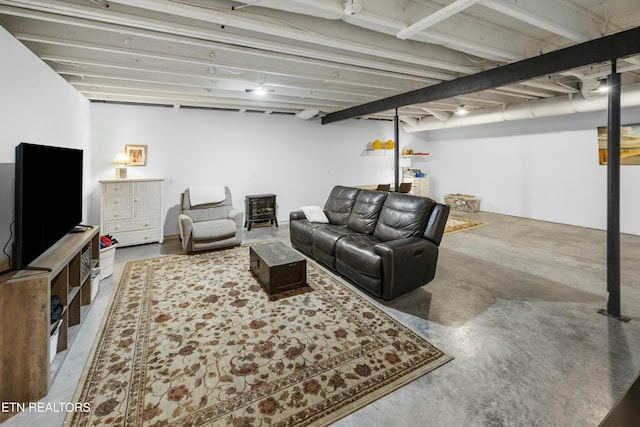 living area featuring concrete floors and a wood stove