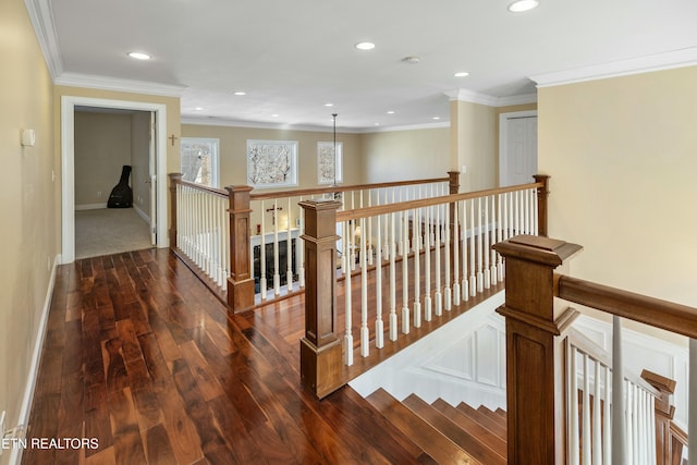 hallway with dark wood-type flooring, an upstairs landing, and crown molding