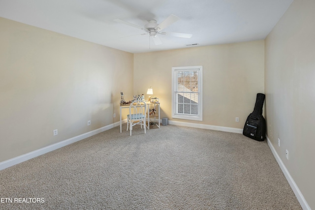 unfurnished office with carpet, visible vents, baseboards, and a ceiling fan