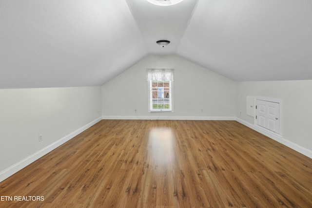 bonus room featuring lofted ceiling, wood finished floors, and baseboards