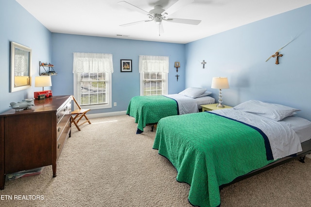 bedroom with light carpet, visible vents, a ceiling fan, and baseboards