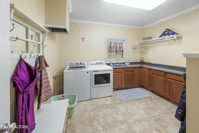 laundry area with a sink, cabinet space, crown molding, and washing machine and clothes dryer