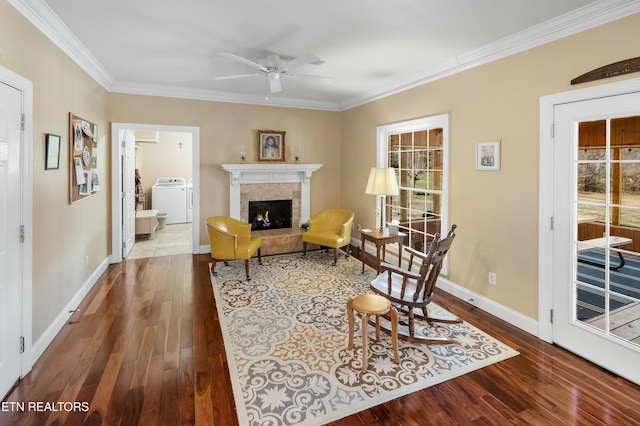 living area featuring washer / clothes dryer, a fireplace, wood finished floors, and baseboards