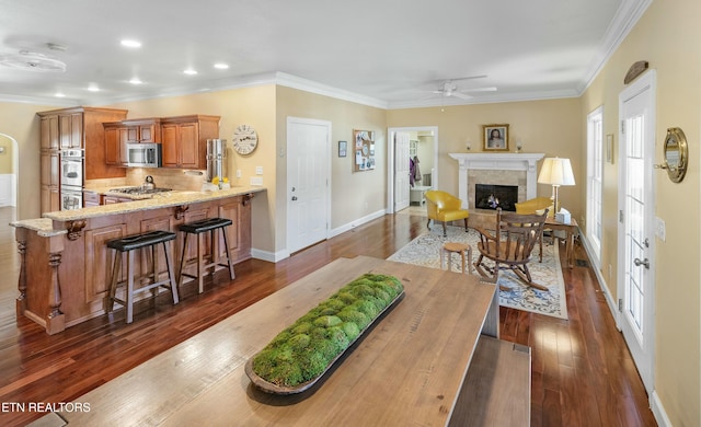 interior space featuring baseboards, dark wood finished floors, ornamental molding, a fireplace, and recessed lighting