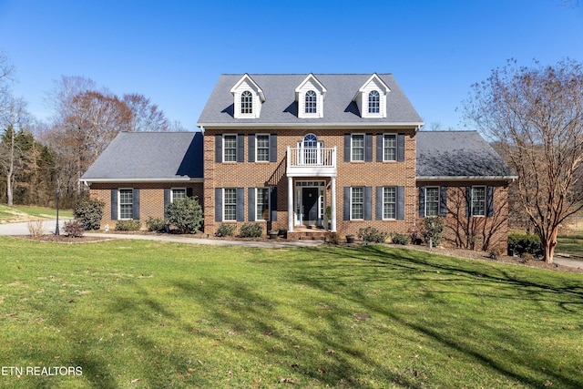 colonial house with a front lawn and brick siding