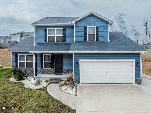 view of front of property with a garage, covered porch, and a front lawn