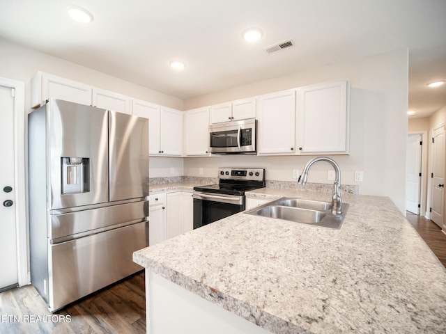 kitchen featuring white cabinets, appliances with stainless steel finishes, sink, and dark wood-type flooring