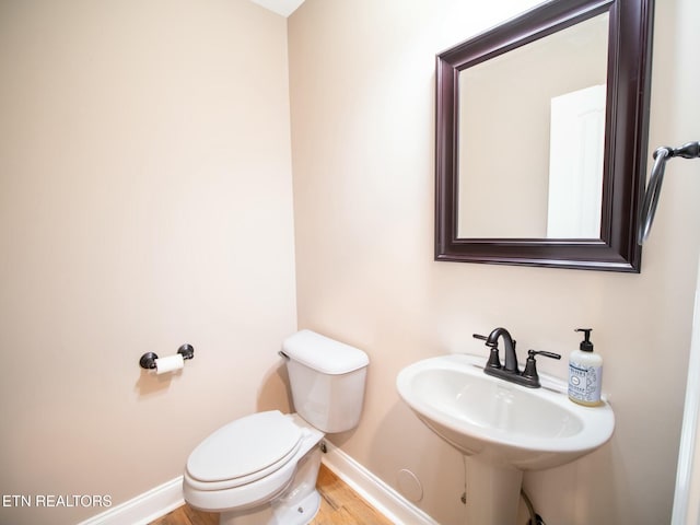 bathroom featuring wood-type flooring, sink, and toilet