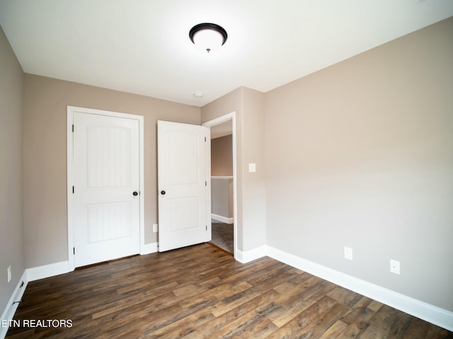 unfurnished bedroom featuring dark hardwood / wood-style floors and a closet