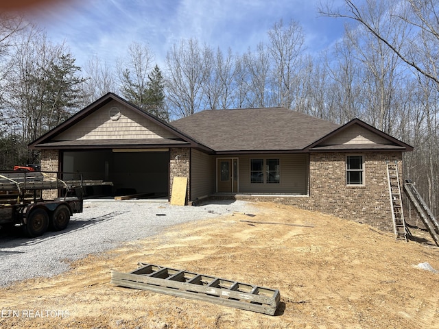180 Hawes Cir, Crossville, TN 38558 - single story home with gravel driveway, an attached garage, brick siding, and roof with shingles