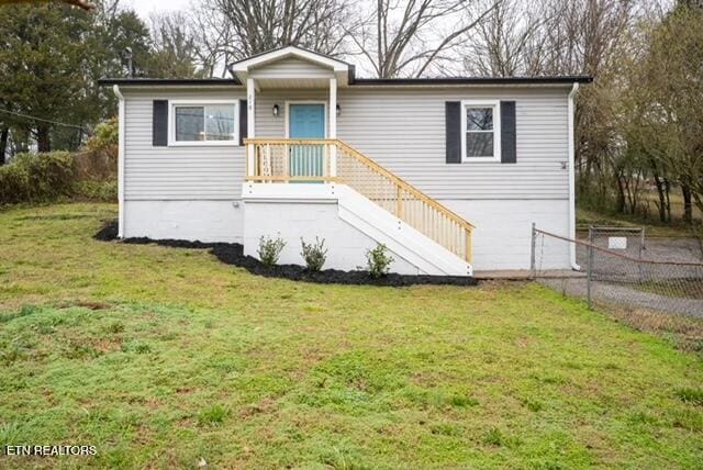 manufactured / mobile home featuring stairway, fence, and a front yard